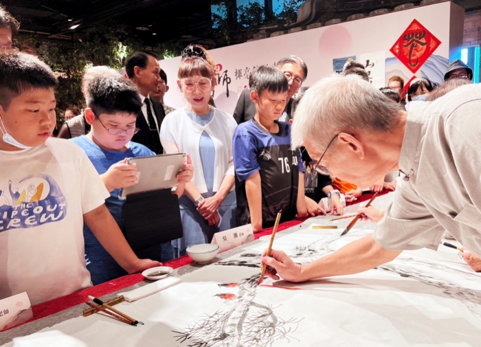 竹北遠百首次與亞東科大合辦「2023名師揮毫筆墨書畫展」，十興國小學童和遠東百貨總經理徐雪芳(左3)一同在現場近距離觀賞書法家揮毫。